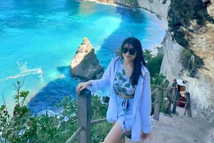 Beautiful Diamond Beach Nusa Penida with woman on stairs – included in East Nusa Penida Tour by The Fun Trev